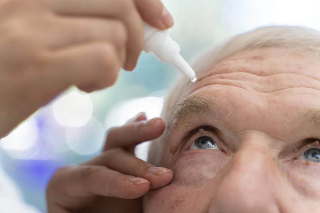 doctor pouring some eye drops patient